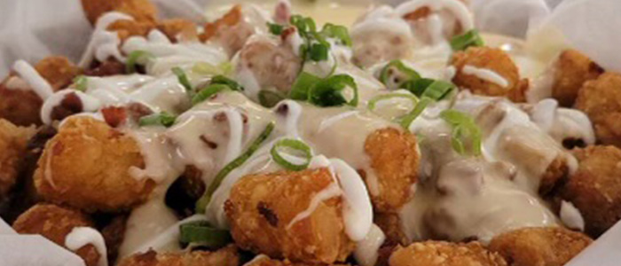 Loaded tator tots with cheese and green onions is a great appetizer for lunch or dinner at Daisy's Garage in Cedar Rapids and Marion Iowa.